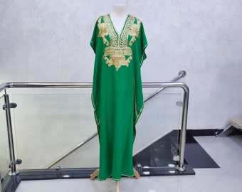 May include: A green kaftan with gold embroidery. The kaftan has a V-neck and short sleeves. The embroidery is intricate and features floral designs.