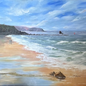 May include: Oil painting of a coastal scene with a sandy beach, ocean waves, and a cloudy blue sky. The artwork depicts a distant headland, a rock formation in the water, and a sailboat. The painting is signed in the lower right corner.
