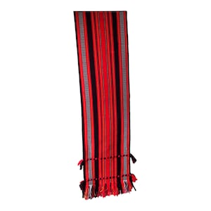 Peut inclure: Un long chemin de table tissé rectangulaire présentant des rayures verticales audacieuses dans des tons rouge vif et noir profond. Le motif inclut de fines rayures blanches et noires sur les bords, avec des franges nouées décoratives.