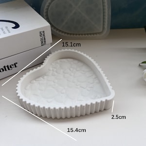 May include: White heart-shaped silicone mold with a textured surface. The mold measures 15.4 inches wide, 15.1 inches long, and 2.5 inches deep.