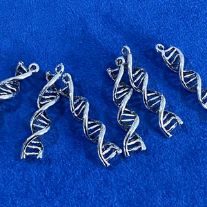 Può includere: Sei ciondoli a doppia elica di DNA color argento. I ciondoli sono dettagliati e hanno una forma a spirale attorcigliata.