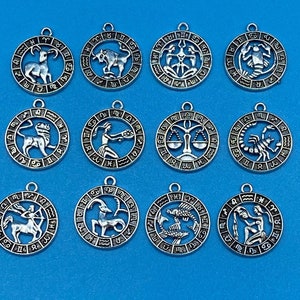 Zestaw 12 okrągłych zawieszek z motywem znaku zodiaku z wyciętymi szczegółami w kolorze srebrnym - zestaw dwunastu sztuk