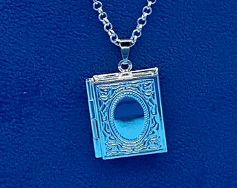 Kleines silbernes Medaillon im Buchstil mit detailliert graviertem Einband, komplett mit Halskette
