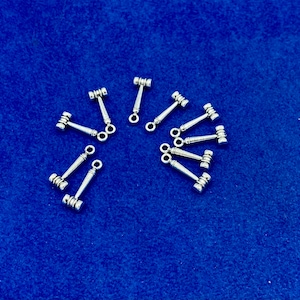 May include: A group of 10 silver-toned gavel charms with a loop for attaching to jewelry or other crafts.