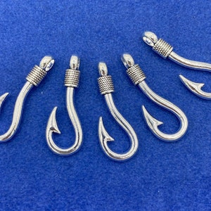 May include: Five silver-toned metal fishing hook charms with a decorative band at the top of each hook.