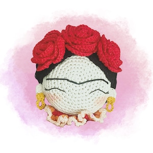 Pode incluir: Boneca de crochê com rosto branco, cabelo preto e uma coroa de flores vermelhas. A boneca está vestindo um vestido de crochê laranja e amarelo.