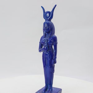 Op de afbeelding: Een blauw lapis lazuli beeld van een Egyptische godin met een hoge hoofdtooi en een voetstuk.