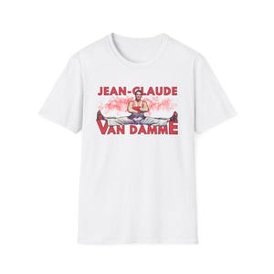May include: White t-shirt with a red graphic of Jean-Claude Van Damme in a split pose with the text "JEAN-CLAUDE VAN DAMME" printed on the front.
