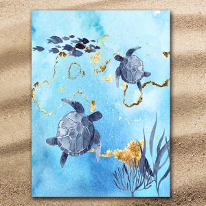 Peut inclure: Serviette de plage à l'aquarelle représentant deux tortues de mer nageant dans un océan bleu avec des accents dorés. Un banc de poissons nage près de la surface. La serviette a un effet aquarelle avec des nuances de bleu et d'or.