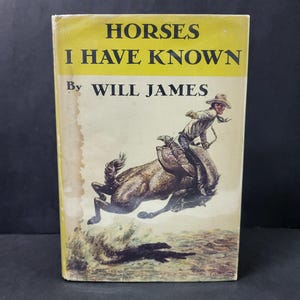May include: Vintage book titled "Horses I Have Known" by Will James. The cover features a yellow background with black text and an illustration of a cowboy riding a bucking horse. The book has a worn appearance.