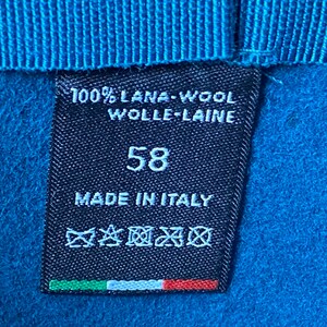 May include: A black label with white text that reads "100% Lana-Wool Wolle-Laine 58 Made in Italy". The label also has a care tag with symbols and an Italian flag.