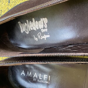 May include: Close-up of the inside of two brown suede shoes. The top shoe has the text "Ingledow Shoes by Rangoni" printed on the insole. The bottom shoe has the text "Amalfi by Rangoni" printed on the insole.