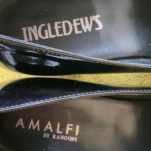 May include: Close-up of the inside of a black leather shoe with the text "INGLEDEW'S" and "AMALFI BY RANGONI" printed on the insole.