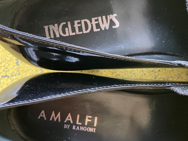 May include: Close-up of the inside of a black leather shoe with the text "INGLEDEW'S" and "AMALFI BY RANGONI" printed on the insole.