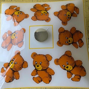 May include: A white background with eight brown teddy bears in different poses. The bears have black eyes and noses and yellow smiles. The background has a yellow border.