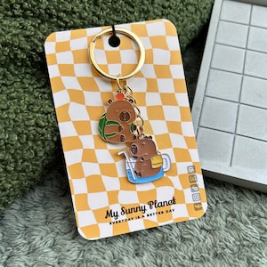 Capybara key ring with matching enamelled pendants and hand-packaged in personalized packaging
