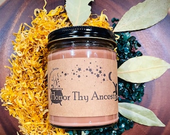 May include: A brown candle with a label that reads "Honor Thy Ancestors" surrounded by dried flowers and leaves.