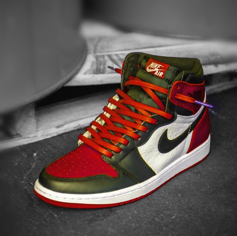 May include: A pair of red and green high-top sneakers with orange laces and a white swoosh logo. The sneakers have the text "Nike Air" on the side.