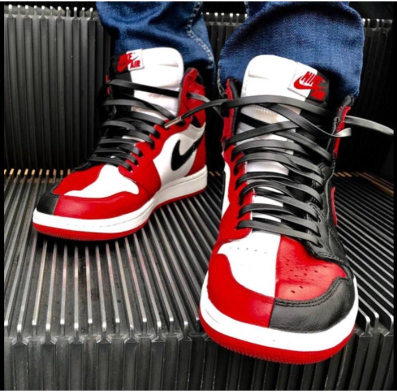 May include: A pair of red, black, and white high-top sneakers with black laces. The sneakers have a white midsole and a red outsole.