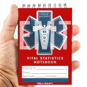 May include: Red notebook with a blue and white star of life symbol and the text "FIELD EQUIPT" and "VITAL STATISTICS NOTEBOOK". The notebook has a spiral binding and blank lines for writing.