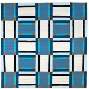 May include: A quilt with a geometric pattern in shades of blue, white, and brown. The quilt is made up of squares and rectangles, and the pattern is created by the different colors and the way they are arranged.