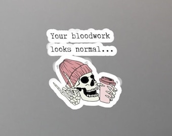 May include: A sticker featuring a cartoon skeleton wearing a pink beanie and holding a pink coffee cup. The text "Your bloodwork looks normal..." is above the skeleton.