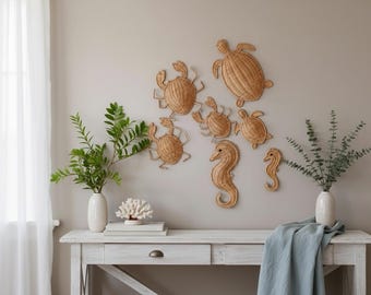 Puede incluir: Una colección de seis decoraciones de pared de ratán tejido con formas de criaturas marinas, incluyendo dos cangrejos, dos tortugas marinas y dos caballitos de mar. Estas piezas texturizadas de color marrón claro están dispuestas en grupo sobre una consola de madera.