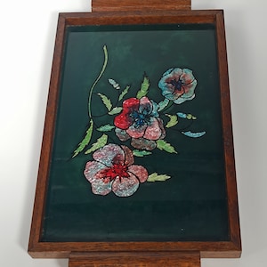 Könnte beinhalten: Ein Serviertablett aus Holz mit einem dunkelgrünen Glaseinsatz, der mit einem Blumendesign verziert ist. Die Blumen sind rosa, rot und blau mit einem glitzernden Finish.