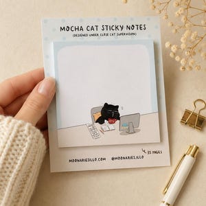 May include: A square pad of Mocha Cat sticky notes with 35 pages. The top header reads MOCHA CAT STICKY NOTES (DESIGNED UNDER CLOSE CAT SUPERVISION). The illustration shows a black cat with glasses at a computer desk with a red mug.