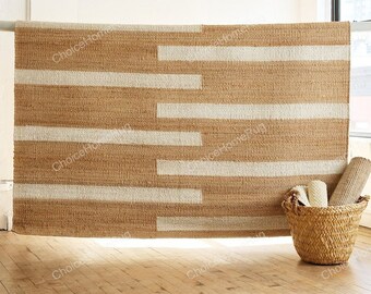May include: A natural fibre rug with a woven pattern of horizontal white stripes on a brown background. The rug is hanging on a wall and there is a wicker basket in the foreground.