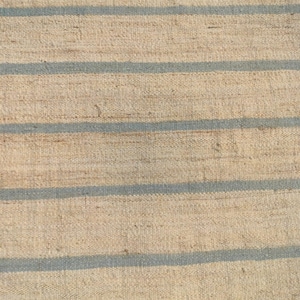 May include: A close-up of a woven rug with horizontal stripes in beige and light blue.