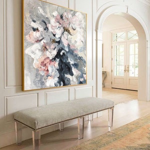 May include: A large abstract painting of pink and white flowers with gray and blue accents hangs above a white bench with clear acrylic legs. The bench is in a hallway with a rug on the floor.