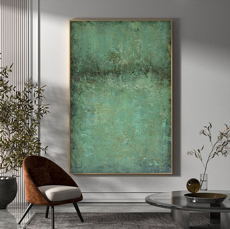 May include: Abstract painting with a textured green and blue colour scheme. The painting is framed in a gold frame and is hanging on a white wall.