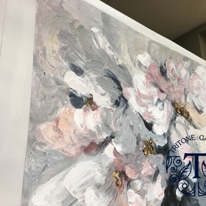 May include: Abstract painting with pink, white, and gray flowers. The painting has a textured, brushstroke effect. The bottom right corner of the painting has the text "Tritone Gallery" and a stylized "T".