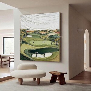 May include: Textured oil painting of a golf course with players. The artwork features a green golf course with sand traps, trees, and a textured white sky. The painting has a neutral color palette with green, brown, and white tones.