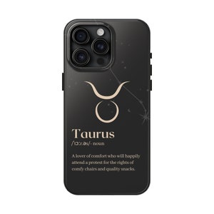 May include: Black phone case with a gold Taurus zodiac sign and constellation design. The text "Taurus /'tɔ:r.ǝs/- noun A lover of comfort who will happily attend a protest for the rights of comfy chairs and quality snacks." is printed on the case.