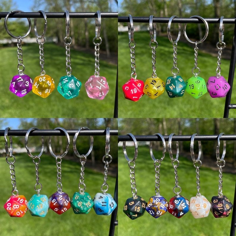 May include: A set of 10 colorful, transparent dice keychains with gold numbers. Each keychain features a different color and number combination. The keychains are attached to silver key rings.