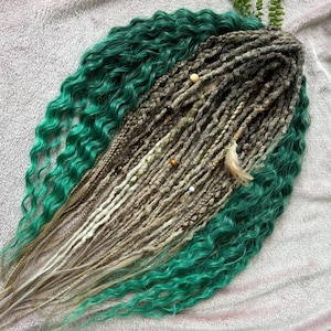 May include: A set of handmade dreadlocks with a mix of colors. The dreadlocks are primarily a light brown and gray color, with accents of green. The dreadlocks are decorated with wooden beads and a feather.