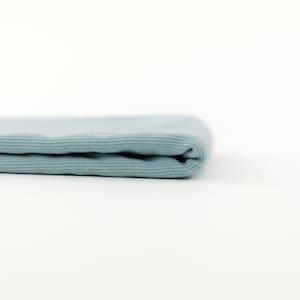 May include: A folded piece of light blue ribbed fabric.