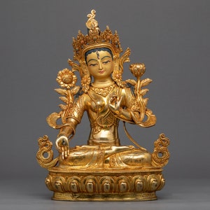 May include: A gold-coloured statue of a seated female deity with a crown and lotus flower. The statue is intricately detailed and has a serene expression.