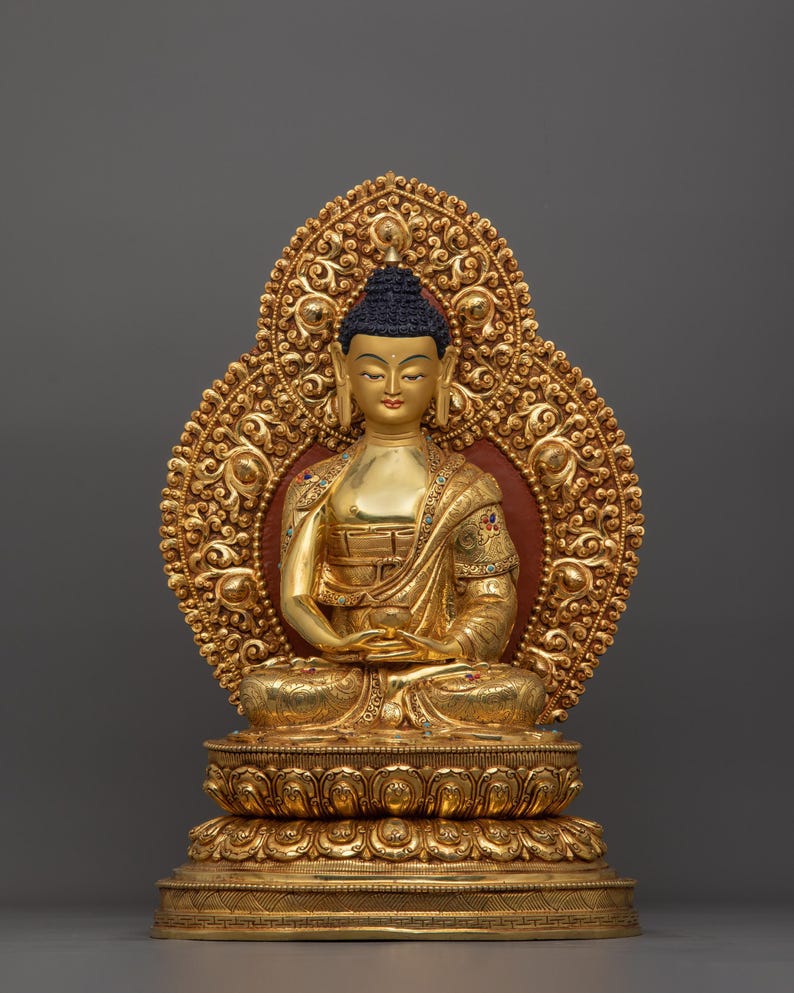 K&ouml;nnte beinhalten: Eine goldfarbene Buddha-Statue, die in meditativer Haltung sitzt. Die Statue ist mit aufwendigen Details verziert und auf einem lotusf&ouml;rmigen Sockel platziert.