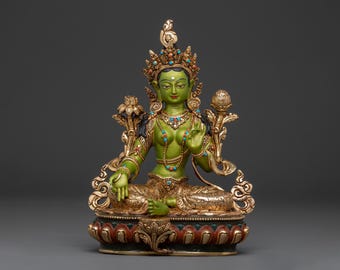 May include: A detailed statue of a seated deity with green skin, adorned with gold and turquoise jewellery. The figure wears a crown and is seated on a lotus flower base. The statue has intricate details and a serene expression.