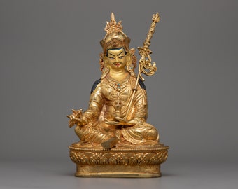 May include: A gold-colored statue of a seated figure with a crown and a scepter. The figure is adorned with intricate details and colorful accents.