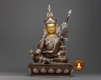 May include: A gold and silver statue of a seated Buddha figure with a crown and a scepter. The statue is on a lotus base with intricate details.