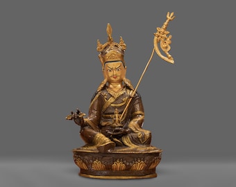 May include: A gold and brown statue of a seated figure with a crown and a scepter. The figure has a serene expression and is adorned with intricate details.