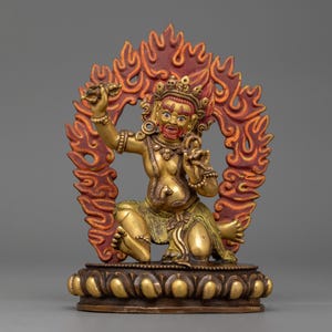 Puede incluir: Una estatua dorada de una deidad con una expresión feroz, sentada en una postura meditativa. La deidad está rodeada por un halo de fuego, simbolizando el poder y la energía. La estatua está elaborada con intrincados detalles y es un hermoso ejemplo del arte tradicional tibetano.