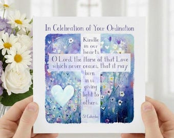 May include: A square greeting card with a cross design, held by hands. The card features a watercolour painting with a blue and purple floral background and the text "In Celebration of Your Ordination". A white heart is in the lower left corner.