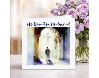 May include: A white greeting card with the text "As You Are Ordained" in blue script. The card features a watercolor painting of a person walking towards a cross in a church. A vase of purple flowers is in the background.