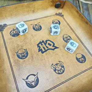 May include: A brown leather game board with a white dice and black illustrations of monsters and skulls. The board has the word "HD" printed on it.