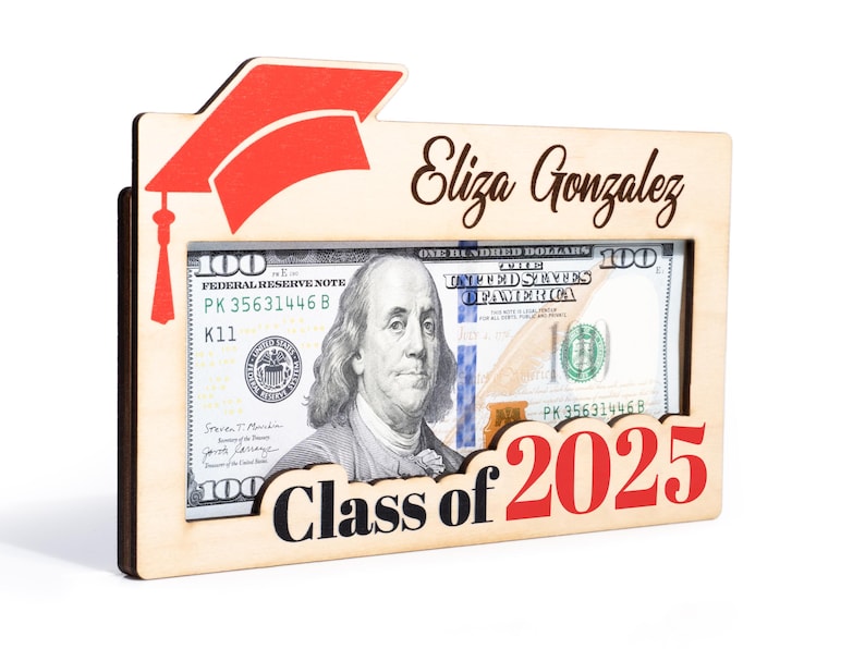May include: A wooden frame with a graduation cap design, a $100 bill inside, and the text "Eliza Gonzalez Class of 2025".